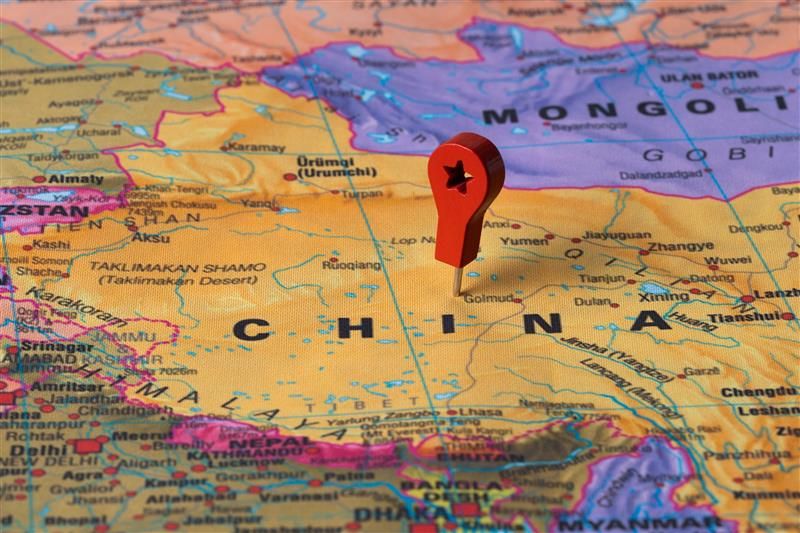 recorte do mapa mundi com a China ao centro e um alfinete vermelho marcando a localização do país