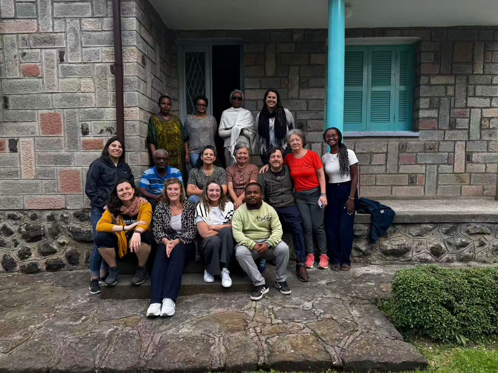 Foto do grupo em frente a uma casa de tijolos aparentes, onde mora as tias de Meron Sileshi